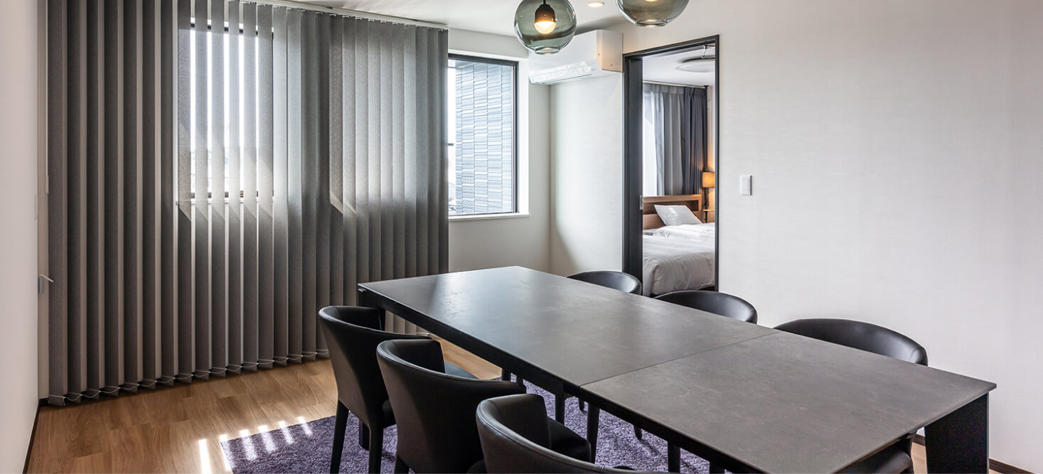 写真：4つの椅子とダイニングテーブルがあるスイートルームのダイニング