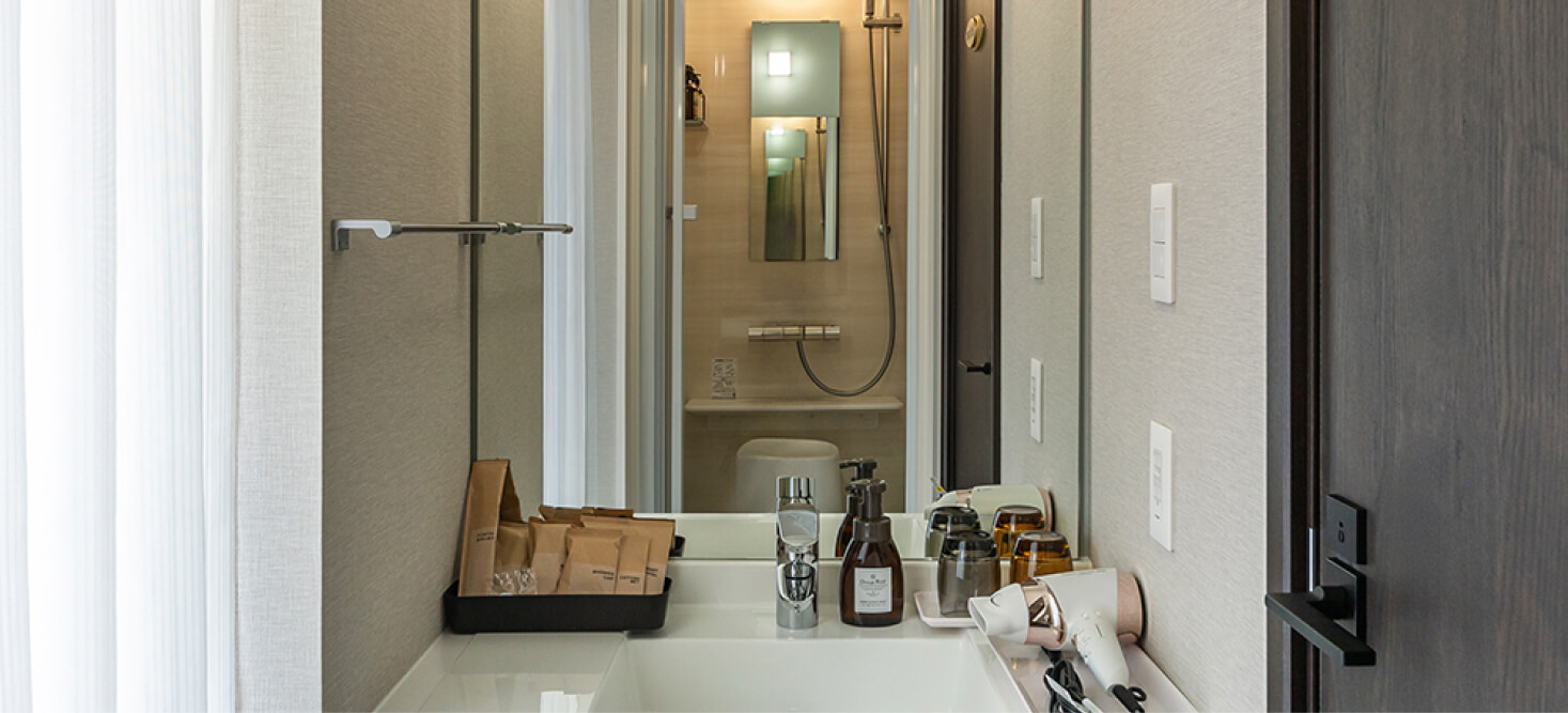 写真：ラージツインルームのアメニティ、ドライヤーが準備されている洗面台 