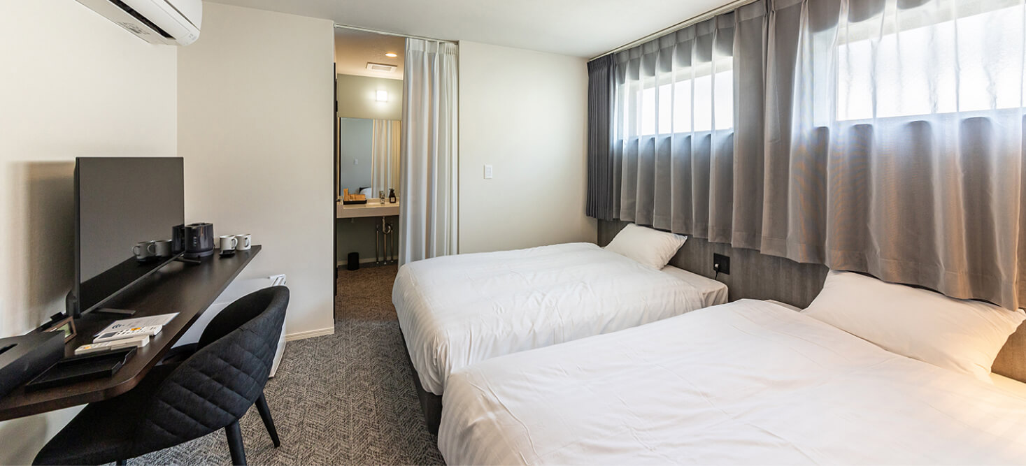 写真：2台のベッドとデスク、テレビが設置されているスタンダードツインルーム